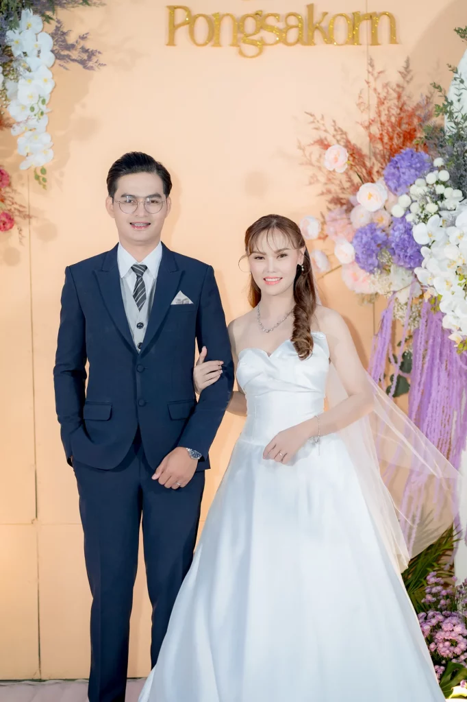 คู่บ่าวสาวบนเวทีท่ามกลางแสงงานเลี้ยงเย็น