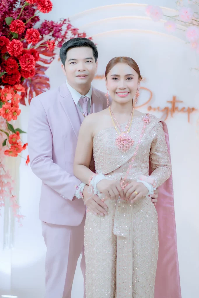 คู่บ่าวสาวในชุดไทยยืนถ่ายภาพร่วมกันหลังพิธี