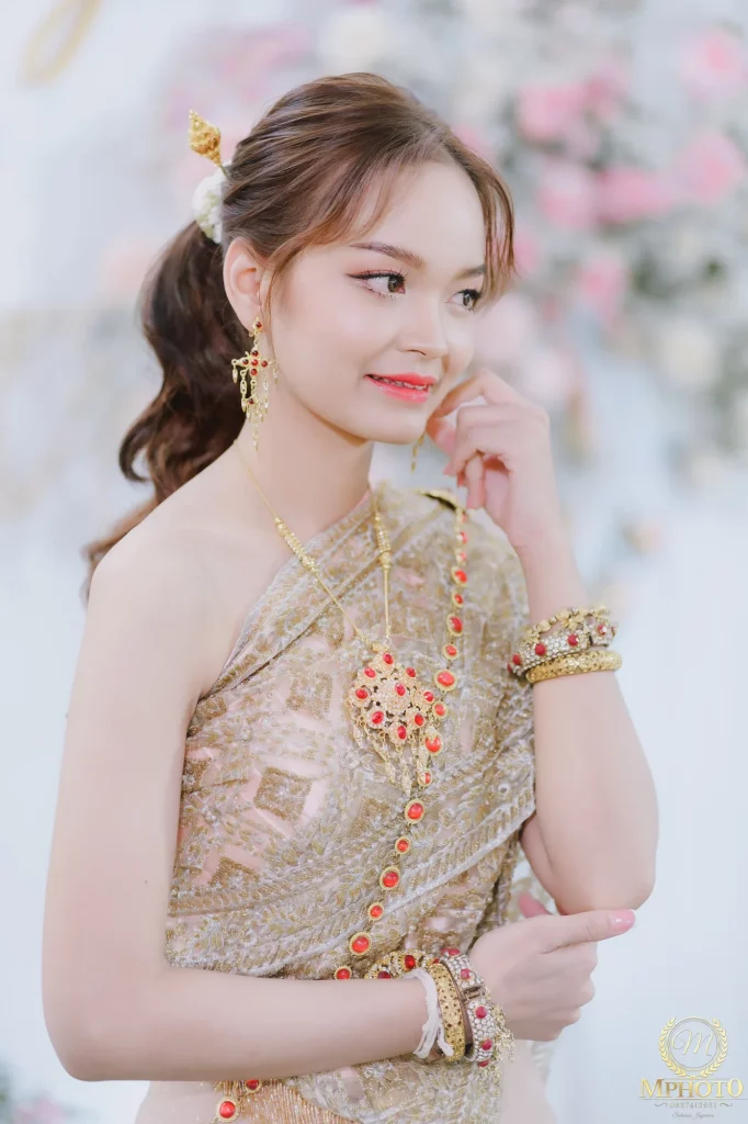 เจ้าสาวในชุดไทยยืนอย่างเป็นธรรมชาติหลังพิธีช่วงเช้า